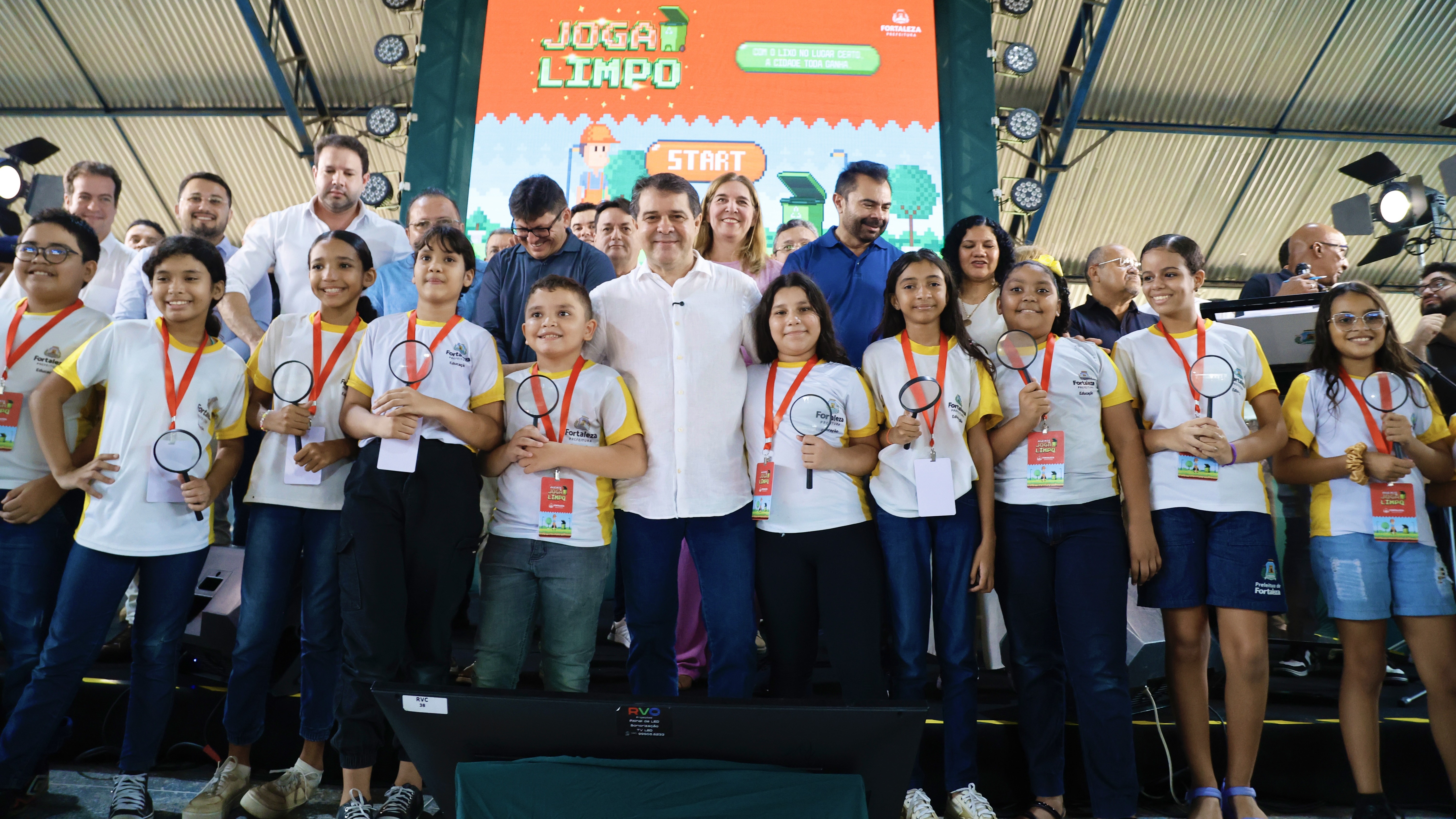grupo de pessoas num palco dentro da quadra de uma escola